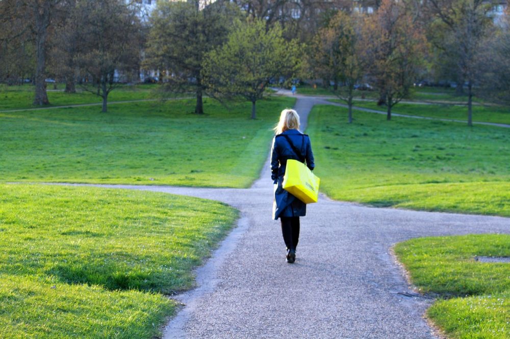 Eine Frau auf einem Fußgängerweg muss eine Richtung auswählen