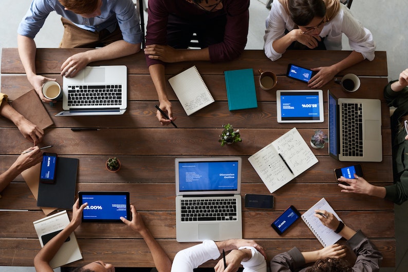 Mehrere Personen am Schreibtisch mit Notebooks